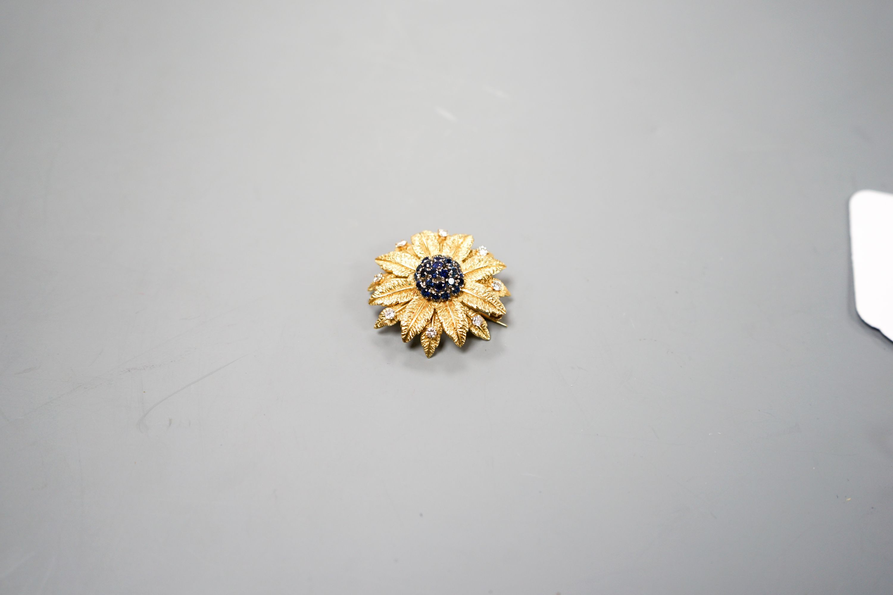 A 1960's 18ct gold, sapphire and diamond cluster set flower head brooch, 35mm.